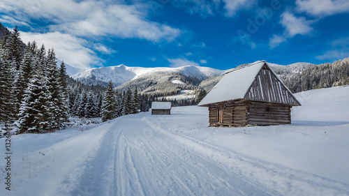 Wooden cottages and snowy road in winter, Tatra Mountains