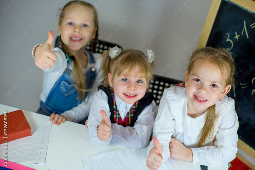 three young schoolgirls sitting at the table three young schoolgirls sitting at the table
