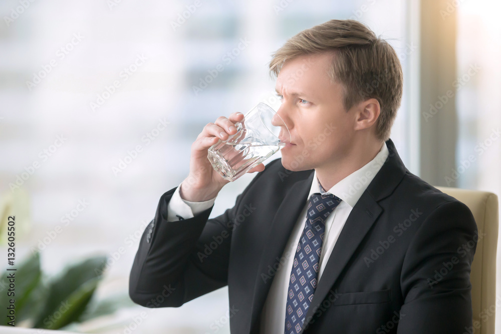 Young handsome businessman, drinking water, feeling tired foggy thinking and poor concentration, hot summer, feeling leaner and fitter, water supply in the office Young handsome businessman, drinking water, feeling tired foggy thinking and poor concentration, hot summer, feeling leaner and fitter, water supply in the office