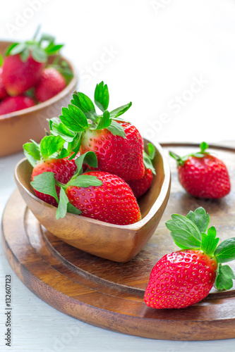 Wooden bowl with a luscious garden strawberries closeup  selecti