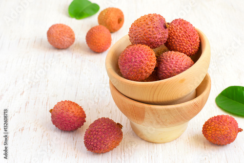 Ripe lychees in a bowl on a white background, copy space photo