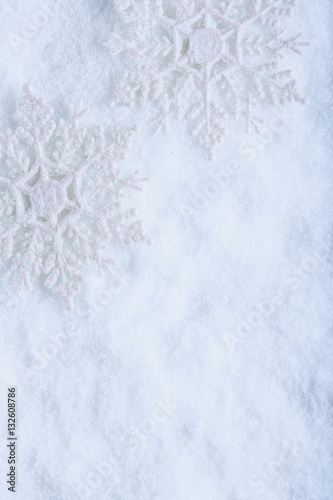 Two beautiful sparkling vintage snowflakes on a white frost snow