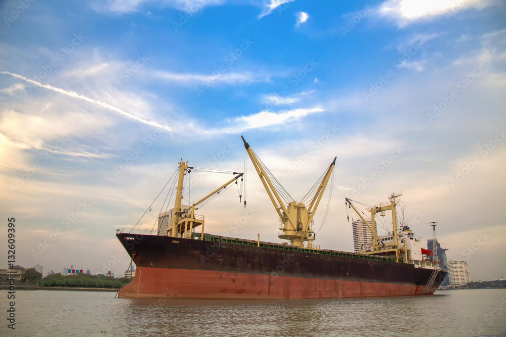 Logistic concept,Cargo ship parked in the river next to the sea. Waiting to dock and load the goods to various destinations. Logistic concept,Cargo ship parked in the river next to the sea. Waiting to dock and load the goods to various destinations.