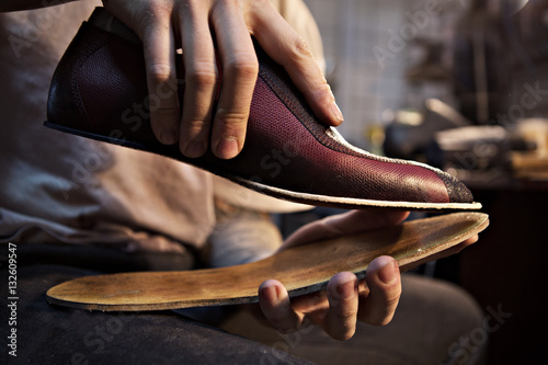 Shoemaker makes shoes for men. He sticks sole © Kateryna