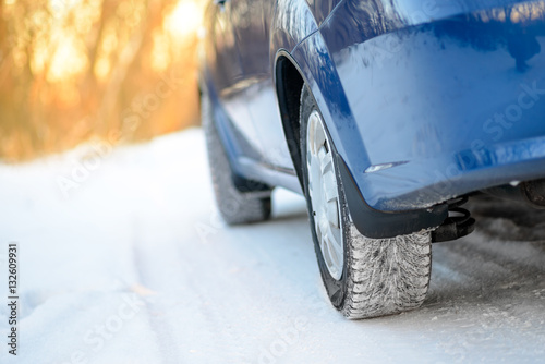 Close-up Image of Winter Car Wheel on Snowy Road. Drive Safe Concept.