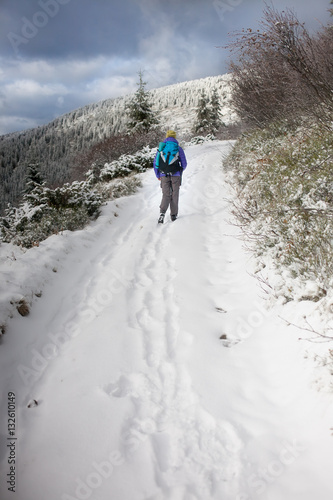 Girl with a backpack in the mountains.