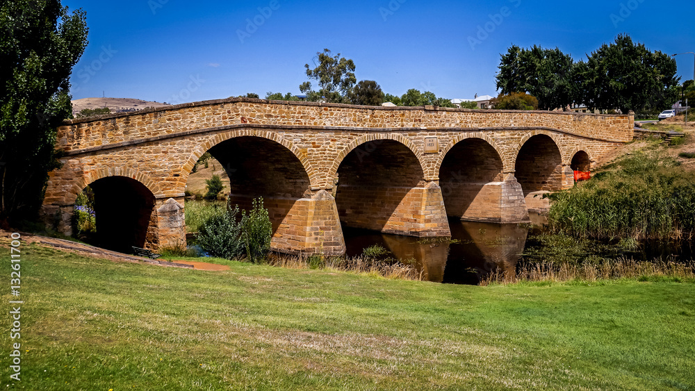 Obraz premium The iconic Richmond Bridge on bright sunny day. Richmond, Tasmania, Australia. Australia's oldest bridge made of stone was built in 1823