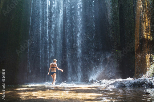 Fototapeta Naklejka Na Ścianę i Meble -  beautiful waterfall in Bali, woman in bikini bathing and swimming in the water