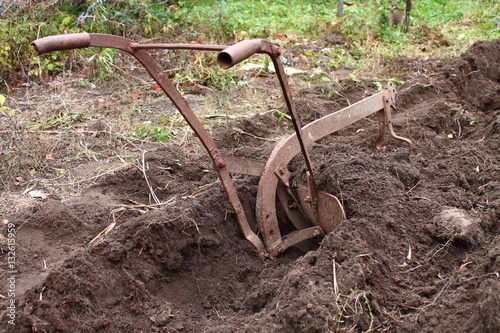 Canvas-taulu old vintage iron plow plowing the soil