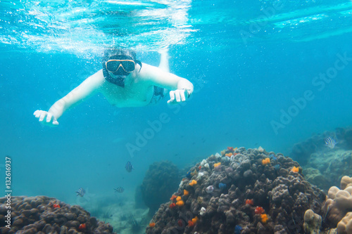 snorkeling underwater, active travels, snorkeler watching corals and fish in the sea