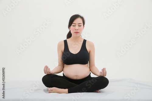 Pregnant Woman Sitting Cross-legged and Doing Meditation