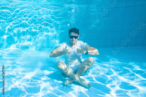 happy man underwater showing OK sign and smiling  travel insurance for tourists concept