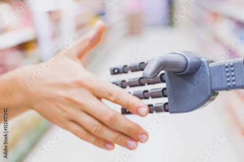 robot and human hands in handshake  high tech in everyday life  meet droid technology