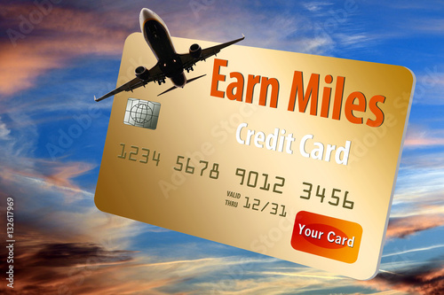 Credit card that offers air mile rewards is seen with a jet plane and dusky sky background photo