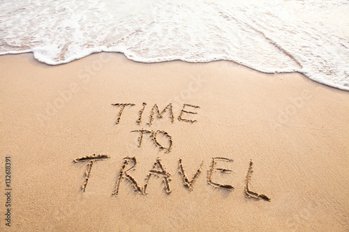 time to travel, concept text drawn on sand of beach