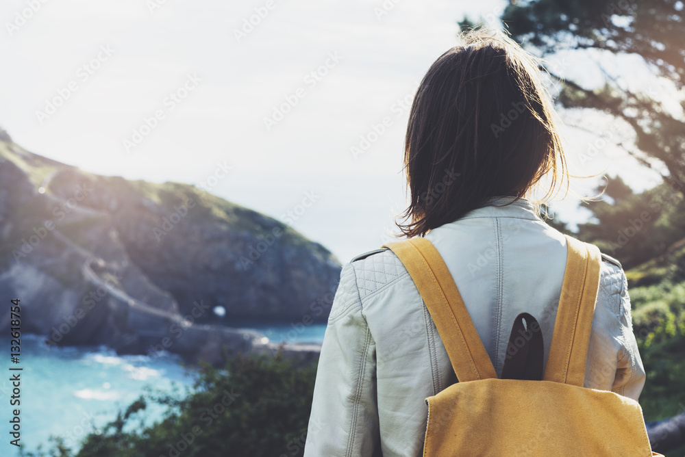Hipster young girl with backpack enjoying sunset on seascape on peak mountain. Tourist traveler on background valley landscape view mockup. Hiker looking sunlight ocean in trip holiday 