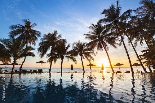 Fototapeta Naklejka Na Ścianę i Meble -  beautiful sunset tropical beach landscape of paradise island with silhouettes of palm trees, summer holidays background