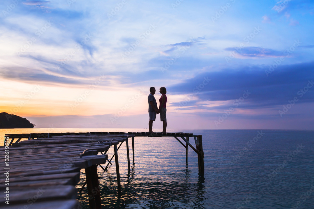 beautiful romantic love background, silhouette of affectionate couple on the pier at sunset beach