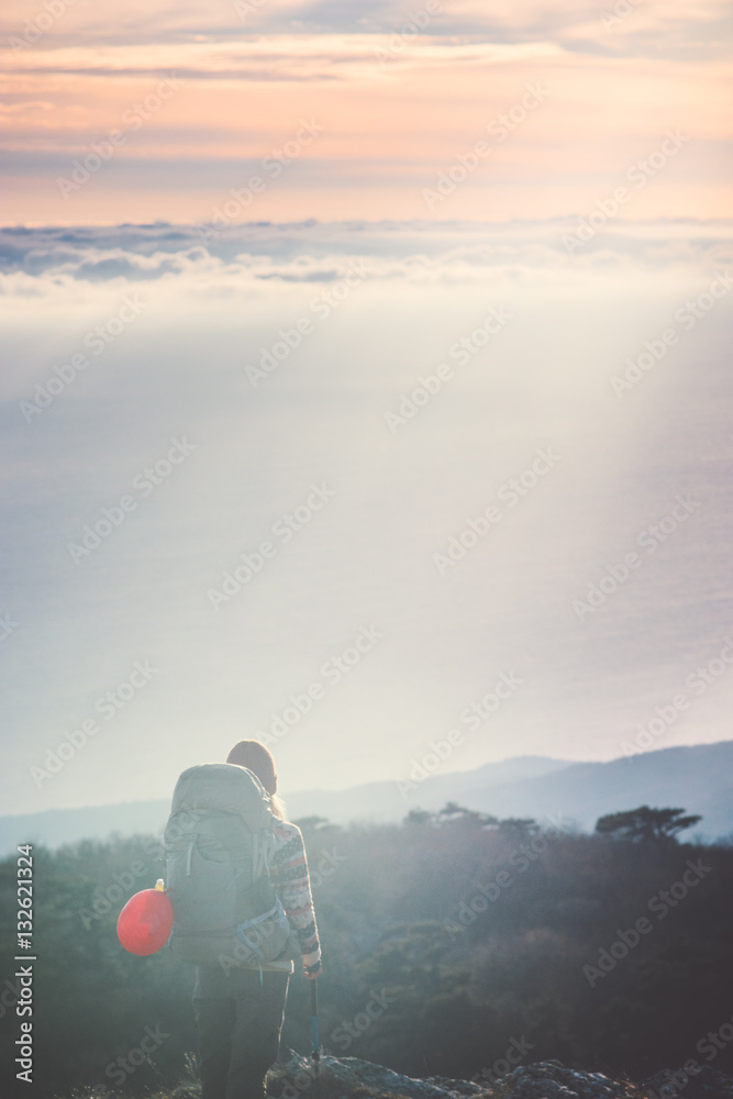 Woman Traveler with backpack hiking on cliff Travel Lifestyle concept adventure active vacations outdoor sunset aerial view from mountain summit on background