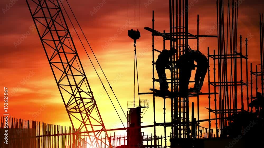 Group of workers build house on sunset sky background.