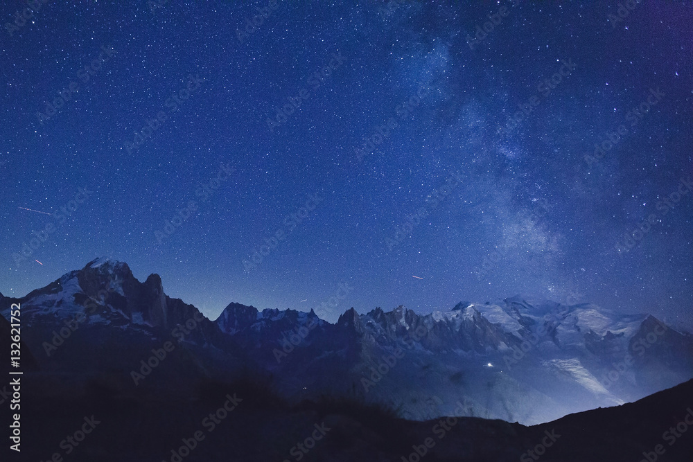 Fototapeta night stars and milky way over alpine mountains, beautiful peaks, nature background