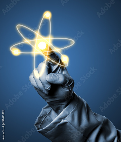 Researcher or scientist with rubber glove holding glowing atom m