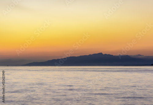 Colorful dark sunset over the sea and mountains