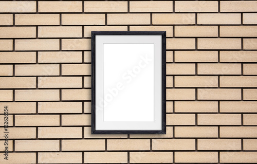 Black wooden photo frame on yellow bricks wall. Gallery style  interior decor mock up