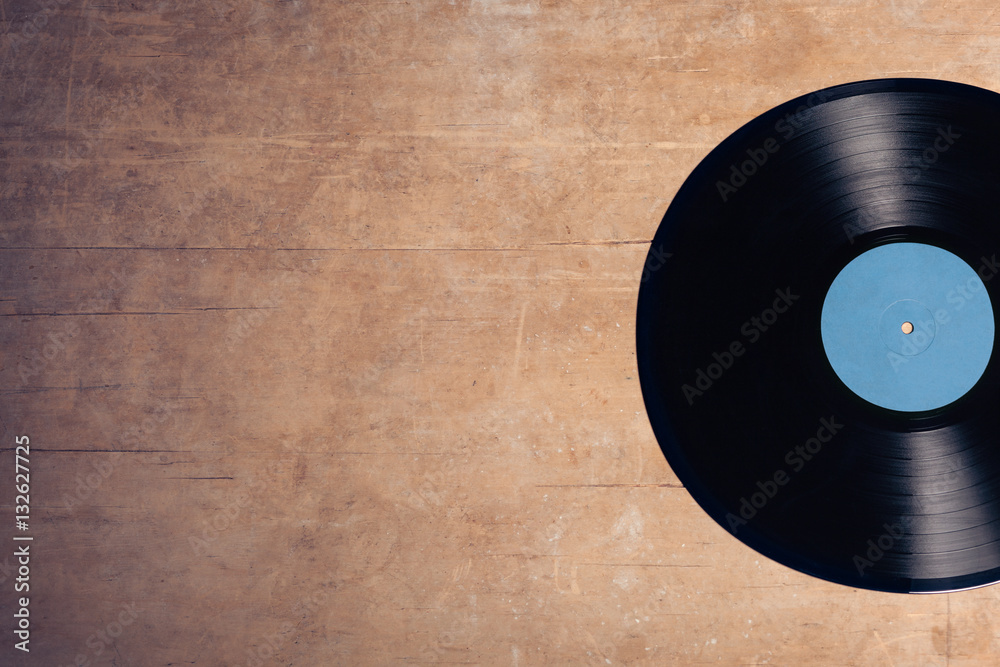 Obraz premium winylowy dysk muzyczny na drewnianym tle;