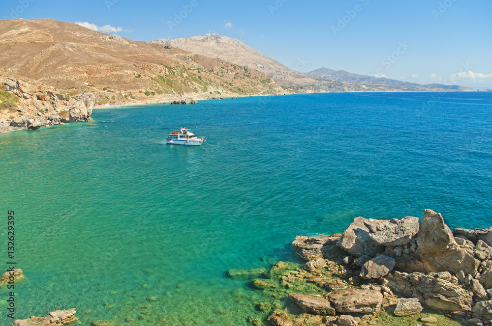 Obraz premium white motor boat at rocky coast