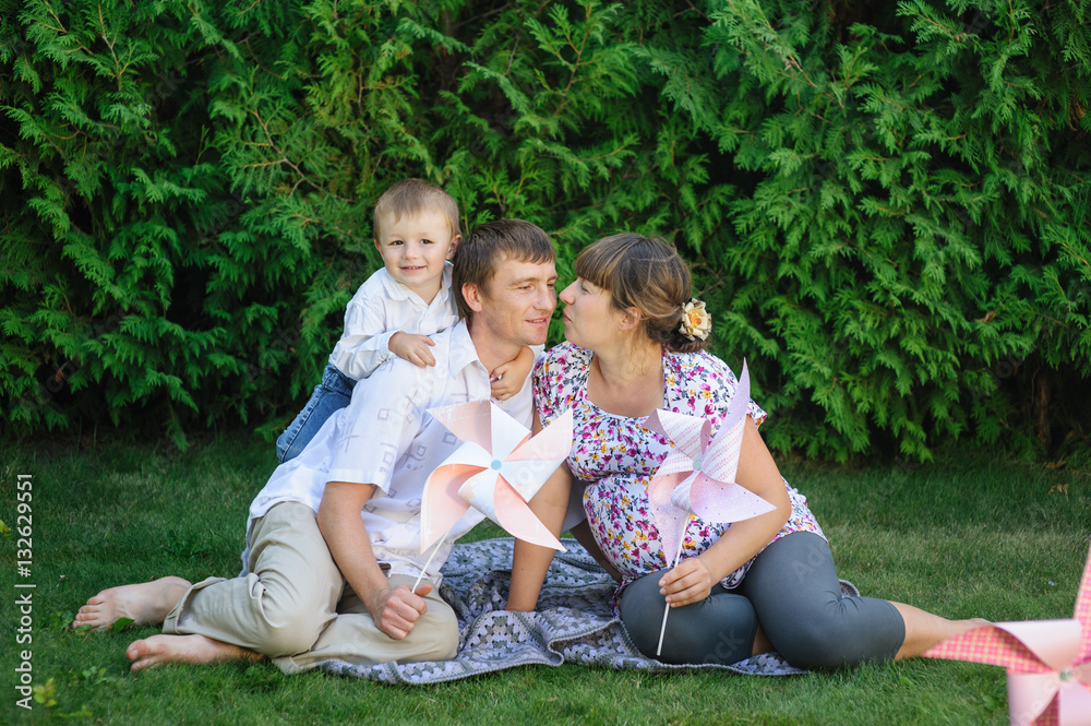 young family sitting on lawn in summer Park young family sitting on lawn in summer Park