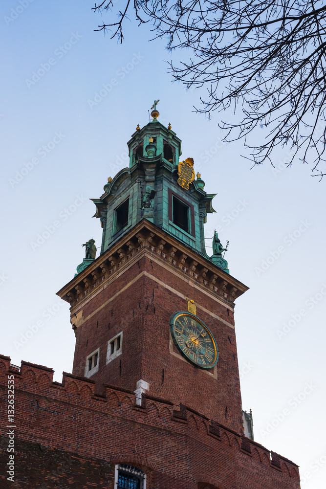 Old medieval tower with a clock against blue sky.