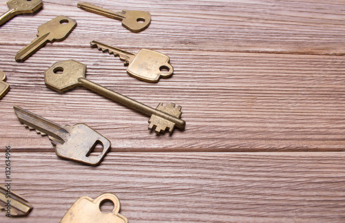 Older different golden keys on a wooden table