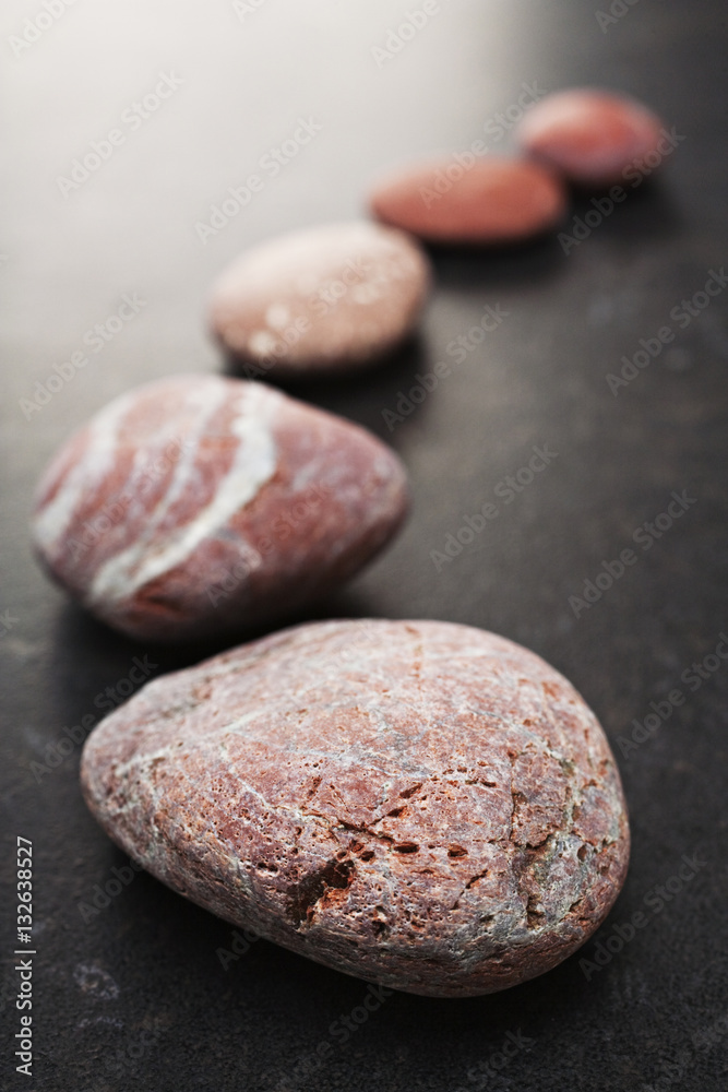 Curving Line of Red and Grey Pebbles on Dark Background Curving Line of Red and Grey Pebbles on Dark Background