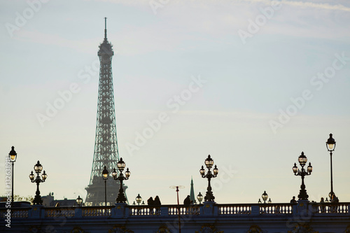 Silhouettes of people and lanterns on the famous Alexandre III bridge and the Eiffel tower