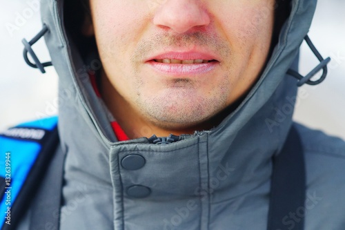 Closeup of a well-groomed man's face. Care for chapped lips in the cold season. Concept of a healthy lifestyle. photo