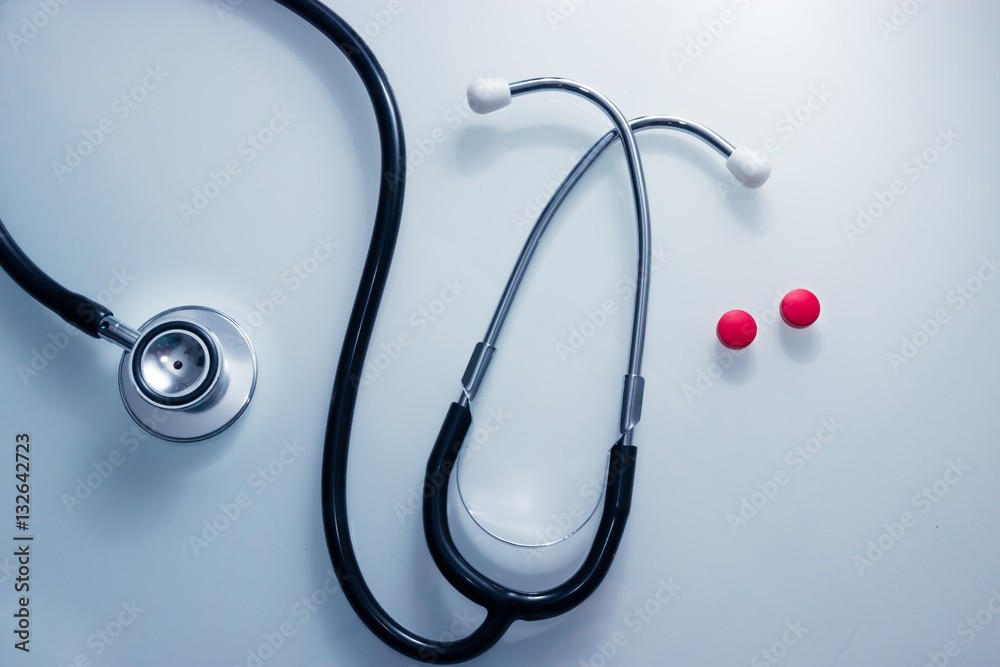 Doctor's Stethoscope snaking around red pills symbolizing emergency heart pressure Doctor's Stethoscope snaking around red pills symbolizing emergency heart pressure