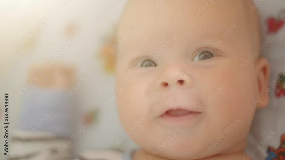 Cute little baby feels joyful. Close up of little child's face in bed. Cute little baby feels joyful. Close up of little child's face in bed.