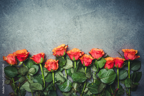 Fototapeta Naklejka Na Ścianę i Meble -  Red roses flowers on gray grunge surface.