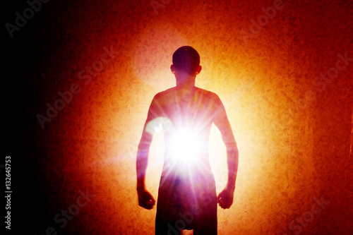 The outline of a man in the darkness with rays of light