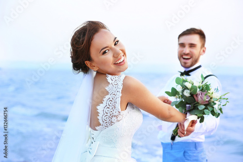 Groom and bride on river ba...