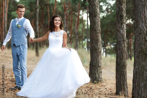 Happy wedding couple walkin...