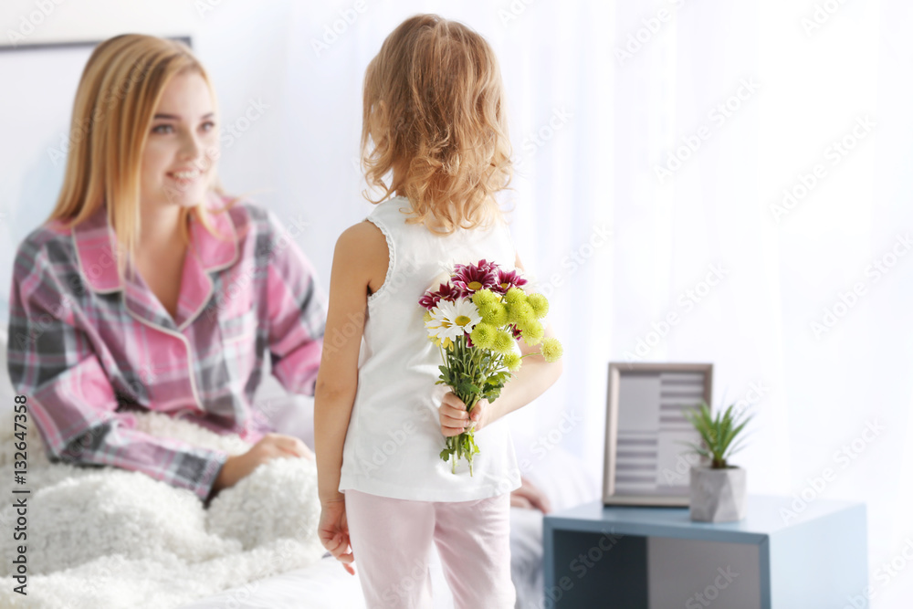 Little girl hiding bouquet of flowers for her mother behind back. Mother's day concept Little girl hiding bouquet of flowers for her mother behind back. Mother's day concept