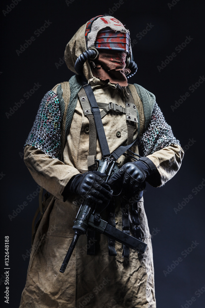 Nuclear post apocalypse life after doomsday concept. Scary closed face of survivor with homemade weapons. Studio closeup portrait on black background Nuclear post apocalypse life after doomsday concept. Scary closed face of survivor with homemade weapons. Studio closeup portrait on black background