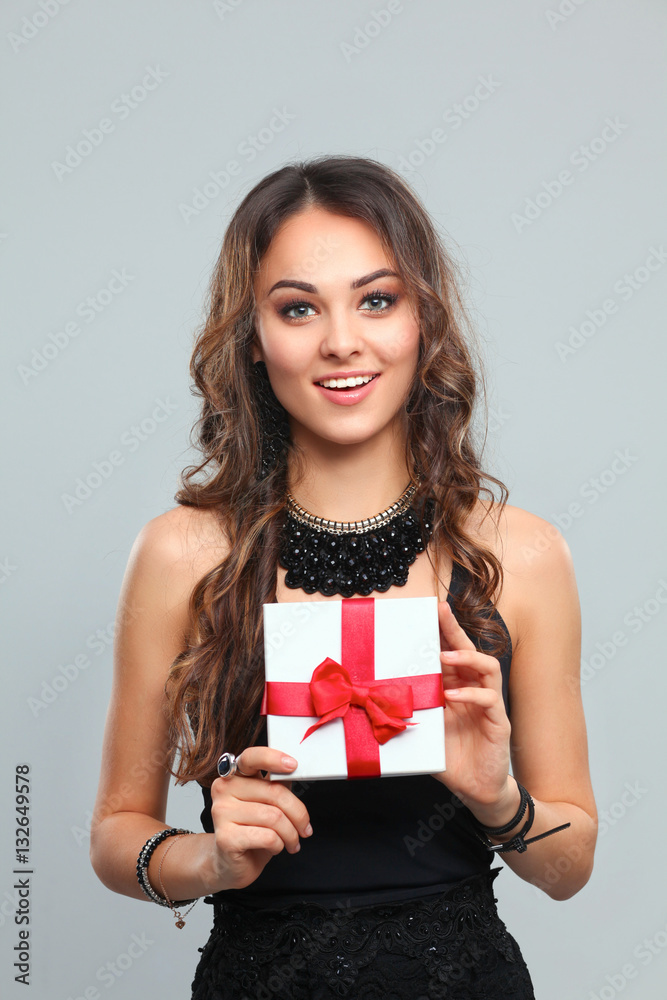 Fototapeta premium Young woman happy smile hold gift box in hands, isolated over gray background