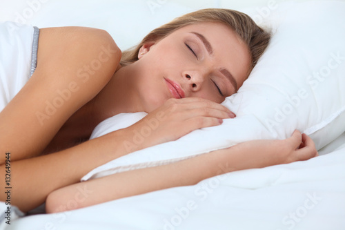 Pretty woman lying down on her bed at home