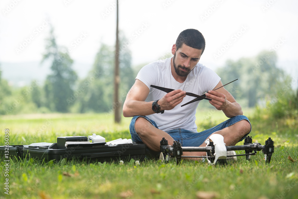 Man Tightening Propeller On Drone in Nature