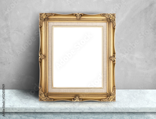 Blank Gold victorian picture frame on white marble table at grey