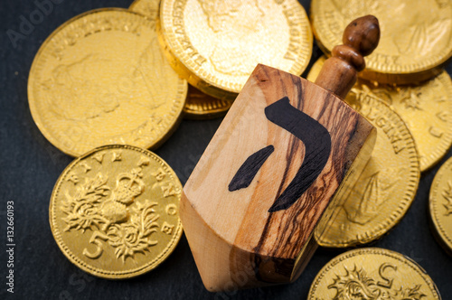 Stacks of Chanukah coins, gelt, large dreidel the traditional Jewish toy, a spinning top used for Hanukkah with copy space photo