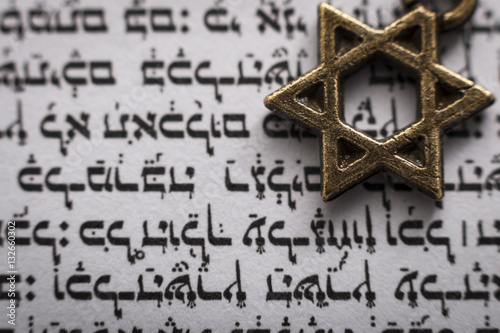 Religion and Judaism concept with closeup on a text in hebrew from the holy Torah and macro on the Star of David